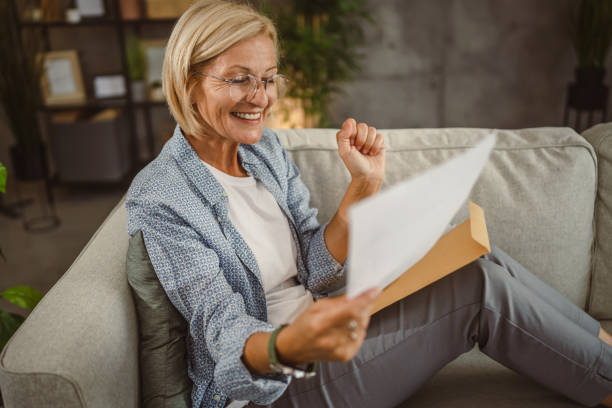 istock Mature woman work from home read letter post envelope with good news 2160738468