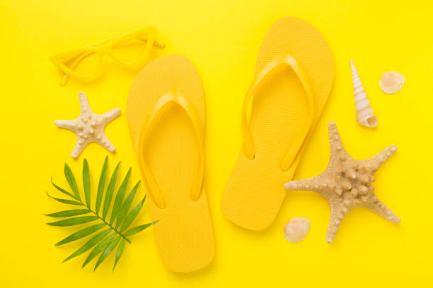 istock Bright yellow flip-flops on color background, top view. Summer concept 2160743031