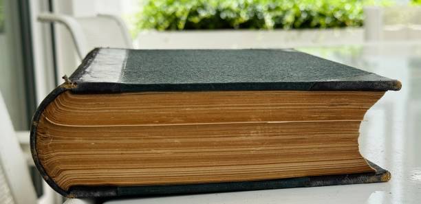 istock Thick old book in the sun, outdoor table 2160744718