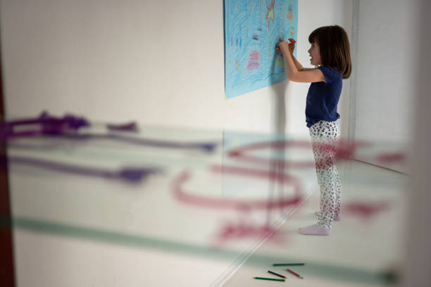 Cute little girl drawing whit crayons in home studio