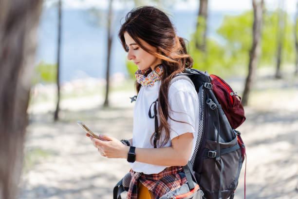 istock Focused girl tourist walking in forest and using smartphone gps 2160749828