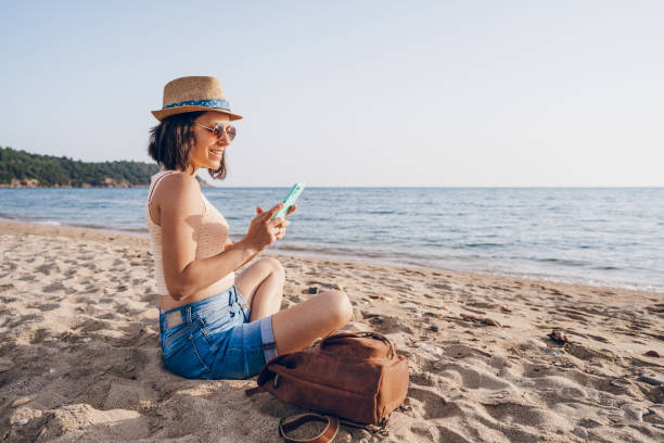 istock Woman using smart phone on the beach 2160750388