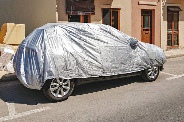 istock Vehicle parked on the street, fully covered with a protective silver tarp 2160759717