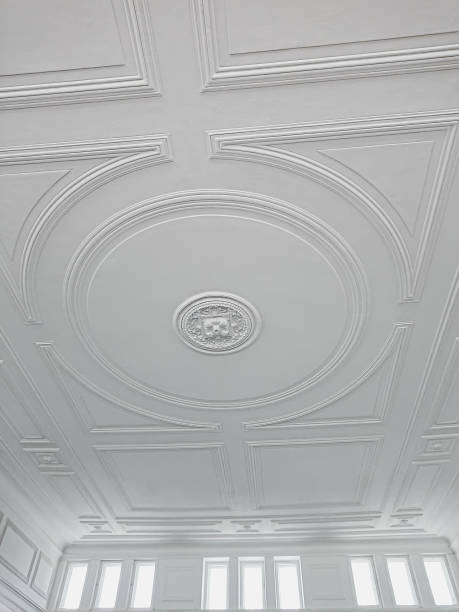 istock White ceiling with decorative molding, light and airy space. White ceiling with intricate moldings, central decoration, and top windows 2160759724