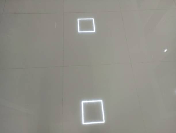 istock On the clean white ceramic on the floor there is a square-shaped light on the ceiling. 2160768889