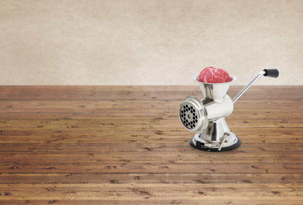 Metal hand meat grinder on a wood table