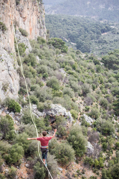 istock A man walks on a tightrope over an abyss. 2160773122