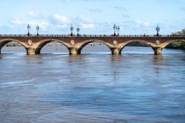 Bordeaux, France, April 17, 2024: Pont de Pierre or Stone Bridge in Bordeaux connects banks of Garonne river, urban tourism, old europe city editorial image
