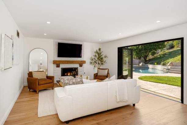 istock Modern living room with fireplace and open sliding doors to a backyard with a pool 2160784412