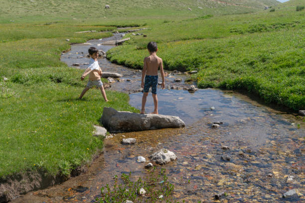 istock little brothers are playing in the stream. 2160786075