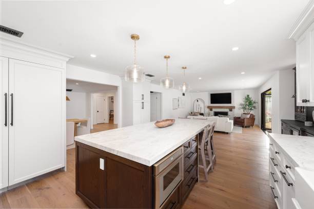 istock Modern open-concept kitchen and living room with white cabinets. 2160787766
