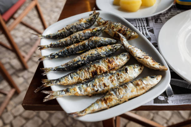 Whole grilled fish on plate on the table