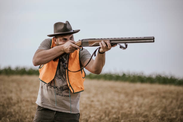 istock Hunter aiming shotgun in field during hunting season 2160792653
