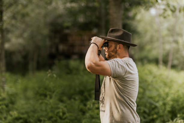 istock A hunter using binoculars to scout wildlife in a forest 2160793000