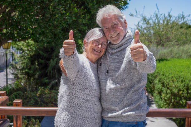 istock Senior couple enjoying a beautiful day outdoors, smiling and hugging each other. Elderly pensioners reflecting their deep bond and affection. Gray-haired joyful Caucasian people in green nature 2160793035