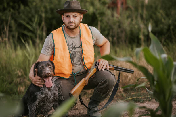istock Hunter with dog and shotgun in a forest 2160793041