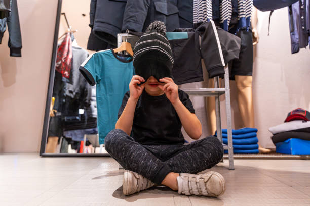 young expressive child having fun posing as a model in a clothing store