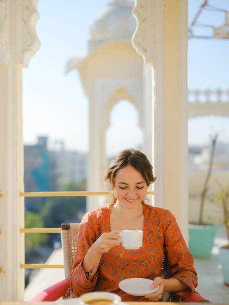istock Woman drinking tea while  having breakfast  on balcony  during trip to India 2160806359