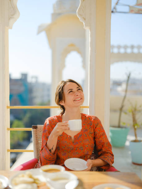 istock Woman drinking tea while  having breakfast  on balcony  during trip to India 2160806575