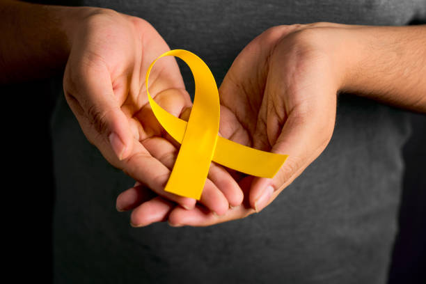 istock Female hands hold yellow suicide prevention day banner symbolizing hope 2160807144