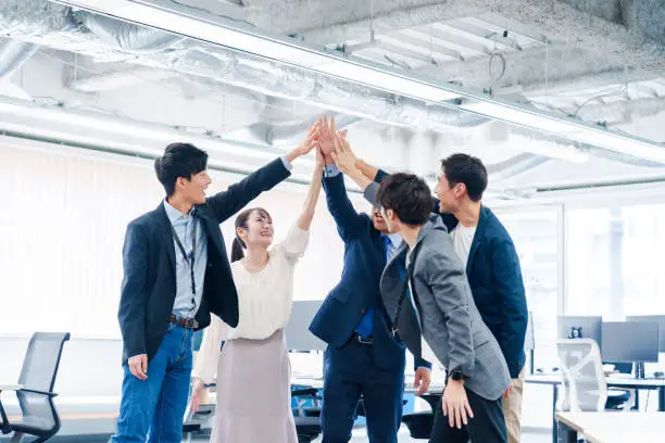 Business people giving high-fives at the office Business people giving high-fives at the office