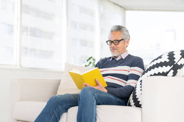 istock elderly man who reads a book, 2160815306