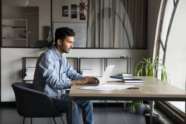 istock Serious focused young Indian project manager man typing on laptop 2160821155
