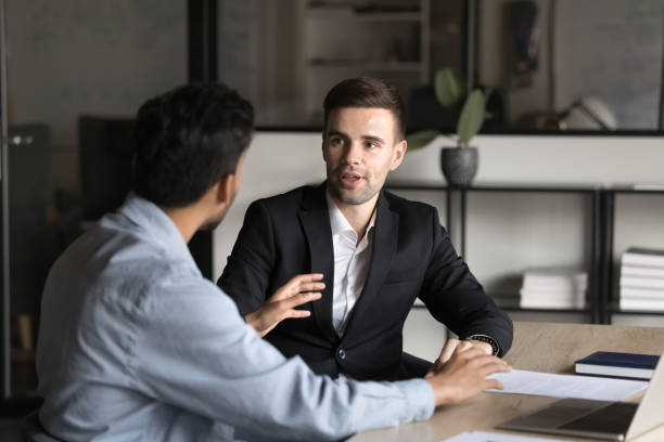 istock Serious diverse business coworkers men talking at workplace table 2160822075