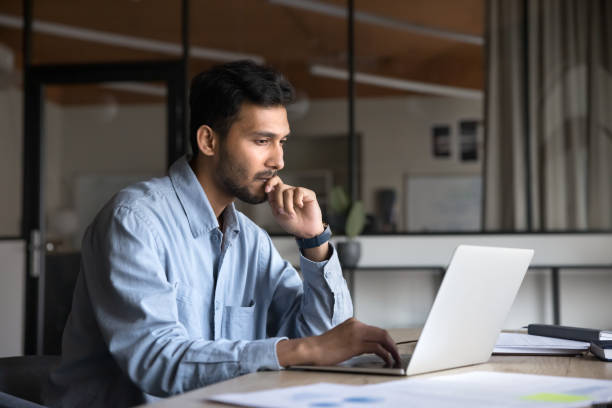 istock Pensive young Indian manager man working at laptop 2160823998