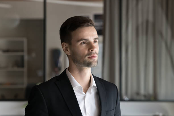 istock Serious pensive handsome businessman in formal jacket standing in office 2160825464