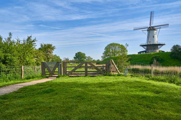Holland, Zeeland - May 12, 2024: Windmill ( de koe ) before a blue morning sky. Technical building from dutch culture in nature. Netherlands, Zeeland, Domburg.