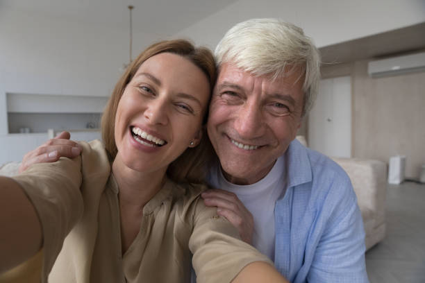 istock Laughing pretty woman and grey-haired father staring at camera 2160836199