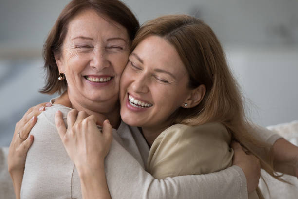 istock Affectionate daughter cuddling tightly her cheerful mature mom 2160836325