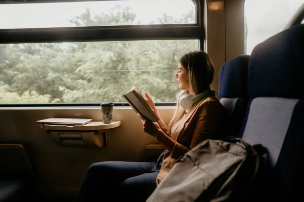 istock young woman travels by train, reading book 2160844236