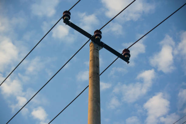 Simple electric poles and cables on a cloudy blue sky background