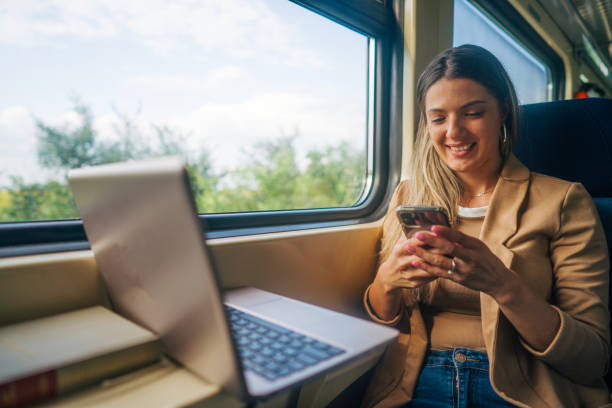 istock young woman travels by train, using lap top and mobile phone 2160844738