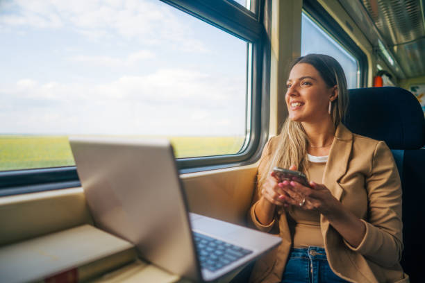 istock young woman travels by train, using lap top and mobile phone 2160844828
