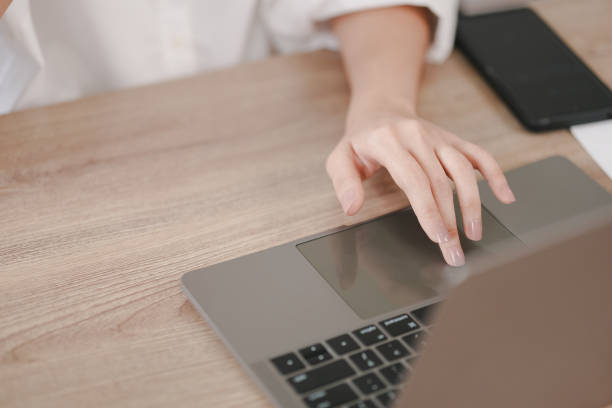 istock A woman is using a laptop on a wooden table 2160845074