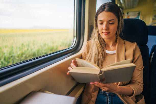 istock young woman travels by train, reading book 2160845116