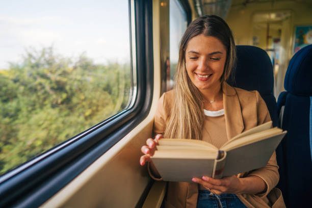 istock young woman travels by train, reading book 2160845174
