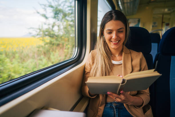 istock young woman travels by train, reading book 2160845175