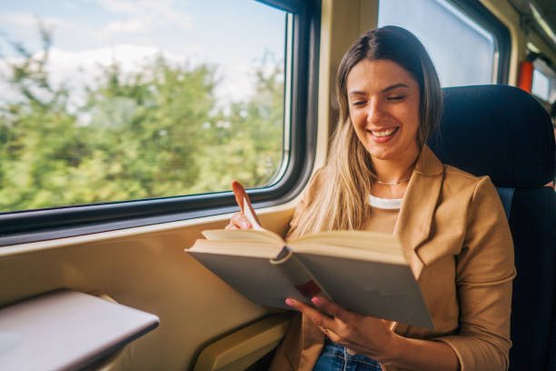 istock young woman travels by train, reading book 2160845219