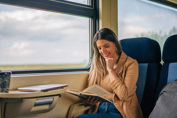 istock young woman travels by train, reading book 2160845276