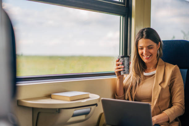 istock young woman travels by train, using laptop and holding coffee 2160845405