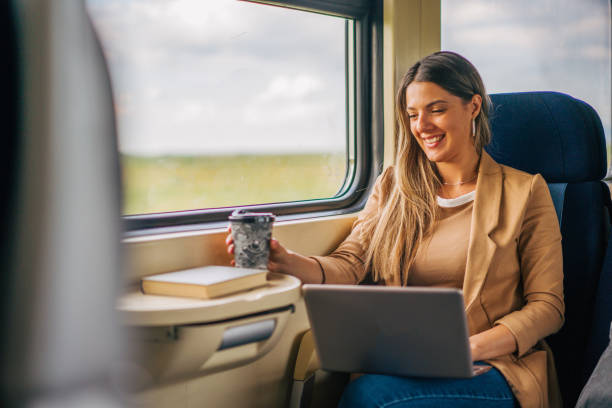 istock young woman travels by train, using laptop and holding coffee 2160845466