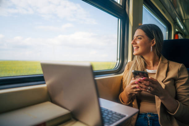 istock young woman travels by train, using lap top and mobile phone 2160846131