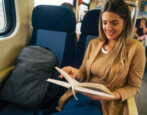 istock young woman travels by train, reading book 2160847936