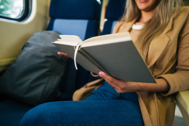 istock young woman travels by train, reading book 2160848362