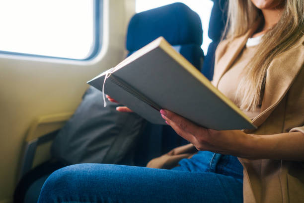istock young woman travels by train, reading book 2160848399