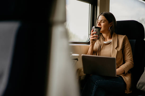 istock young woman travels by train, using laptop and holding coffee 2160848450